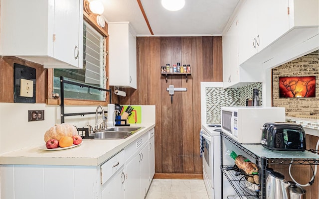 kitchen with crown molding, white appliances, white cabinetry, and sink