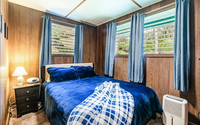 bedroom featuring carpet floors, multiple windows, and wood walls