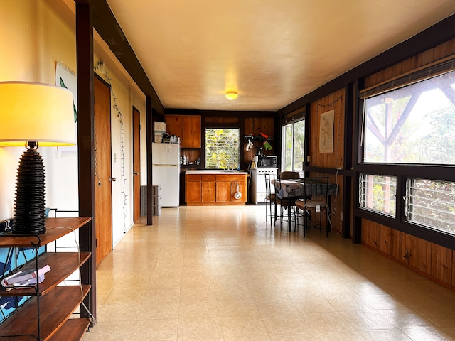 interior space featuring wooden walls and white fridge