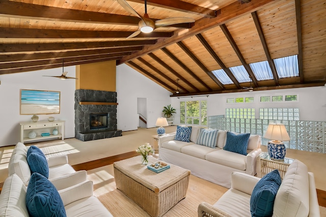 living room featuring beamed ceiling, a stone fireplace, wood ceiling, and high vaulted ceiling