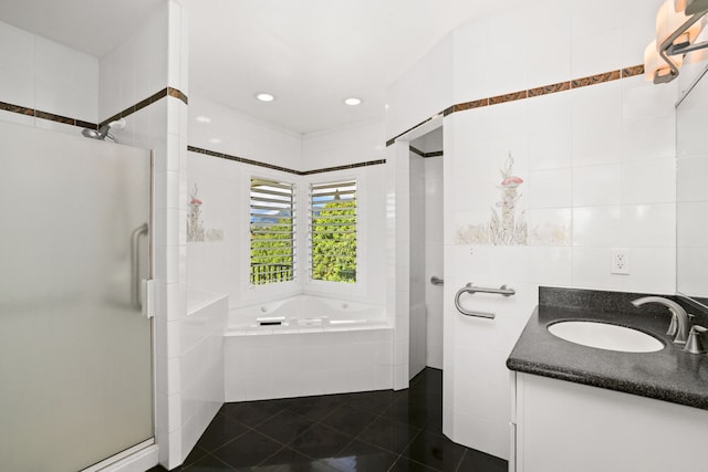 bathroom with tile patterned floors, vanity, separate shower and tub, and tile walls