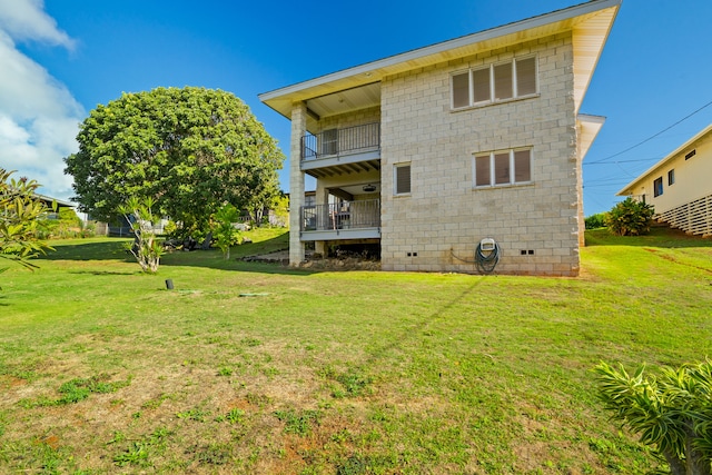 back of property featuring a balcony and a lawn