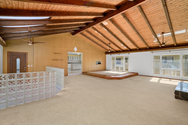 unfurnished living room featuring a healthy amount of sunlight, carpet floors, and beam ceiling