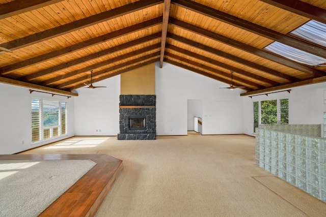 unfurnished living room with beamed ceiling, a stone fireplace, light colored carpet, and high vaulted ceiling