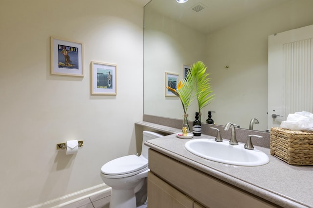 bathroom with tile patterned flooring, vanity, and toilet