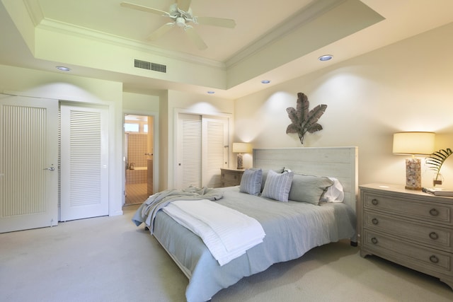 carpeted bedroom featuring ceiling fan, ornamental molding, connected bathroom, and a tray ceiling