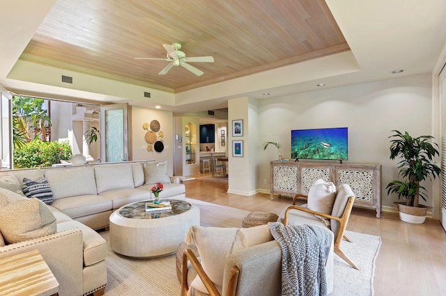 living room featuring a tray ceiling, light hardwood / wood-style flooring, and wooden ceiling