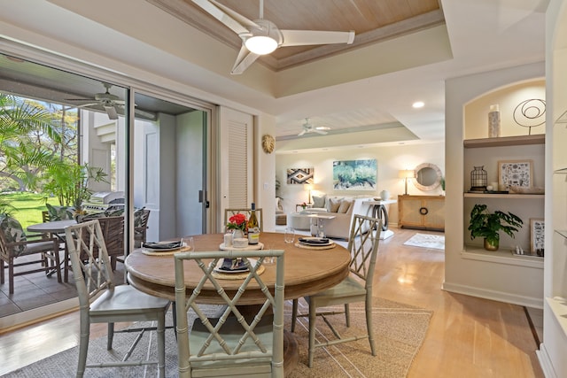 dining area with wooden ceiling, a tray ceiling, and light hardwood / wood-style floors