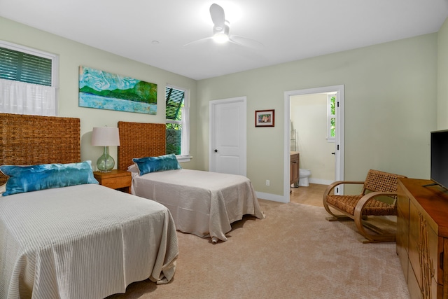 carpeted bedroom with connected bathroom and ceiling fan