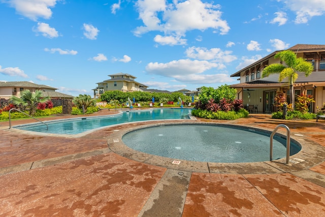 view of swimming pool featuring a patio and a hot tub