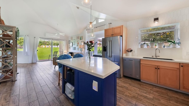 kitchen featuring sink, ceiling fan, decorative light fixtures, a kitchen island, and stainless steel appliances