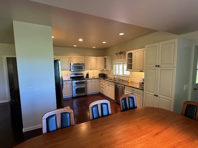 kitchen featuring tasteful backsplash, stainless steel appliances, sink, dark hardwood / wood-style floors, and white cabinetry