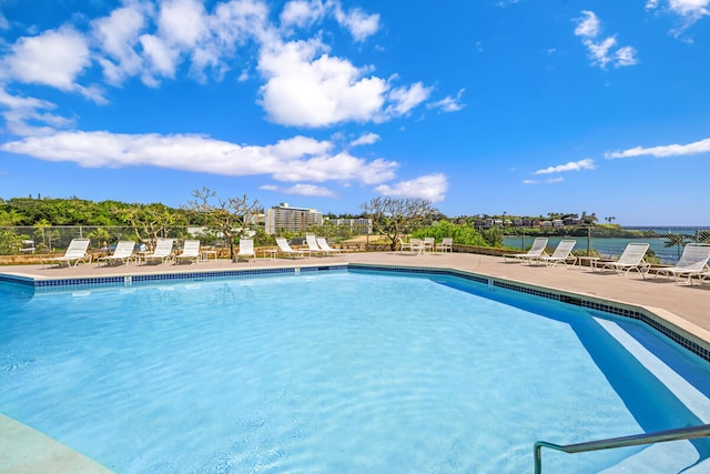 view of pool featuring a patio area and a water view