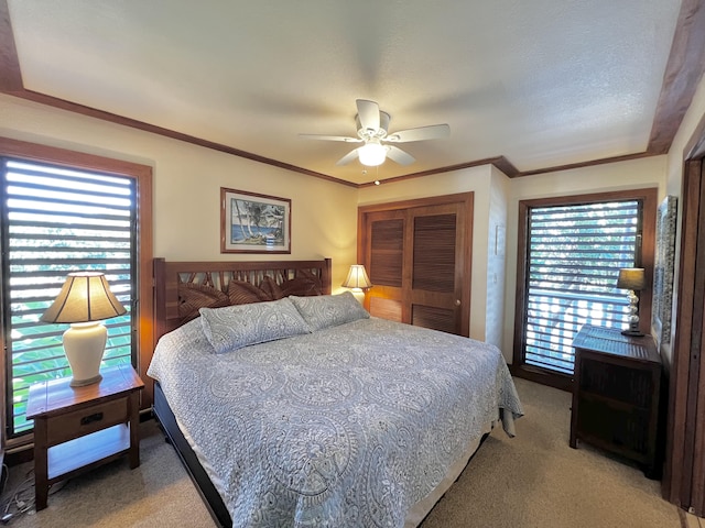 bedroom featuring carpet, ceiling fan, crown molding, and a textured ceiling