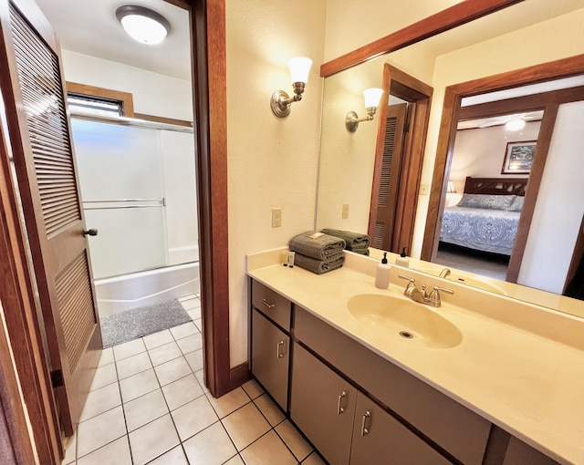 bathroom with tile patterned flooring, vanity, and enclosed tub / shower combo