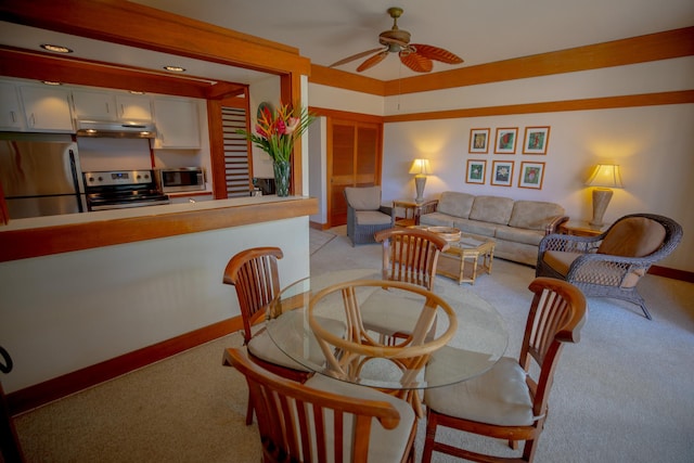 carpeted dining area featuring ceiling fan