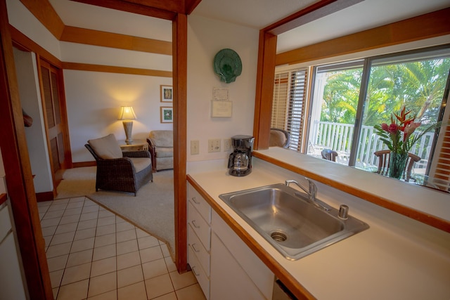 kitchen with white cabinets, light tile patterned floors, and sink