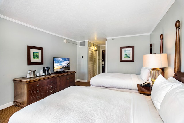 carpeted bedroom featuring ornamental molding, a textured ceiling, and a closet