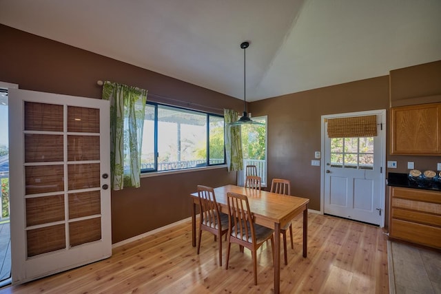 dining space with light hardwood / wood-style flooring, a wealth of natural light, and lofted ceiling