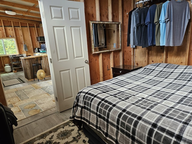 bedroom with wooden walls and light wood-type flooring