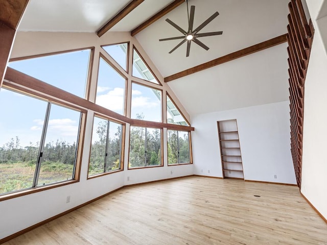 unfurnished living room with beam ceiling, light wood-type flooring, a wealth of natural light, and ceiling fan