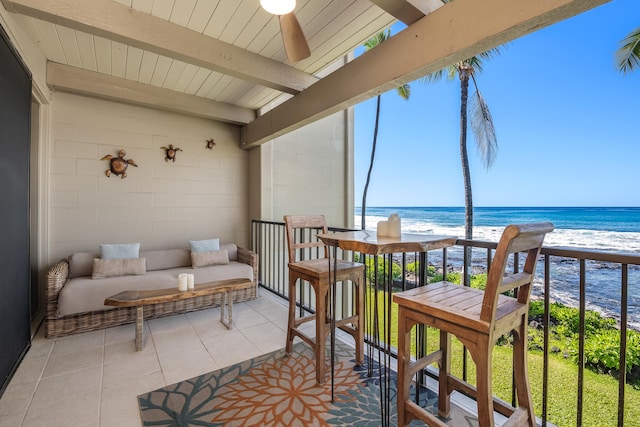 sunroom / solarium with a view of the beach, beam ceiling, a water view, and ceiling fan