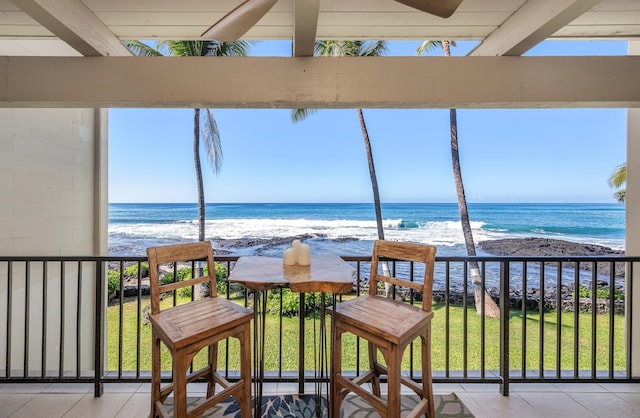 sunroom featuring a view of the beach and a water view