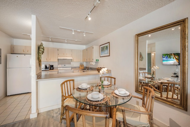 dining room featuring a textured ceiling, light hardwood / wood-style floors, and sink