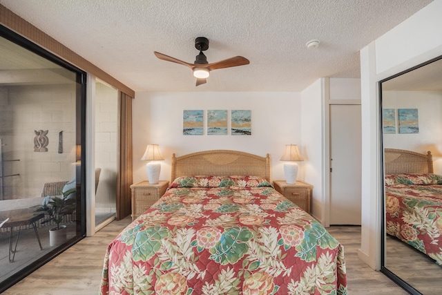 bedroom with ceiling fan, light wood-type flooring, and a textured ceiling