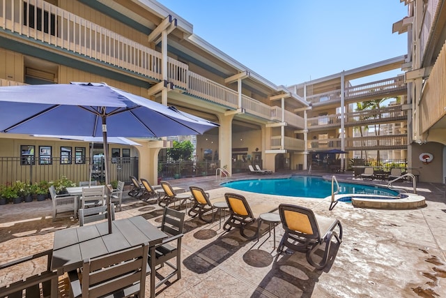 view of swimming pool with a patio and a hot tub