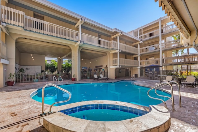 view of swimming pool with a patio and a hot tub