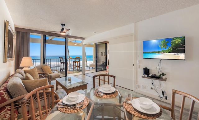 dining space with ceiling fan, floor to ceiling windows, wood-type flooring, and a textured ceiling