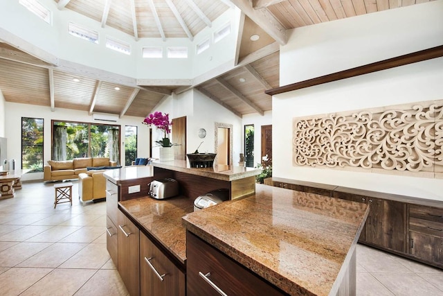 kitchen featuring a kitchen island, beamed ceiling, high vaulted ceiling, light tile patterned floors, and wood ceiling