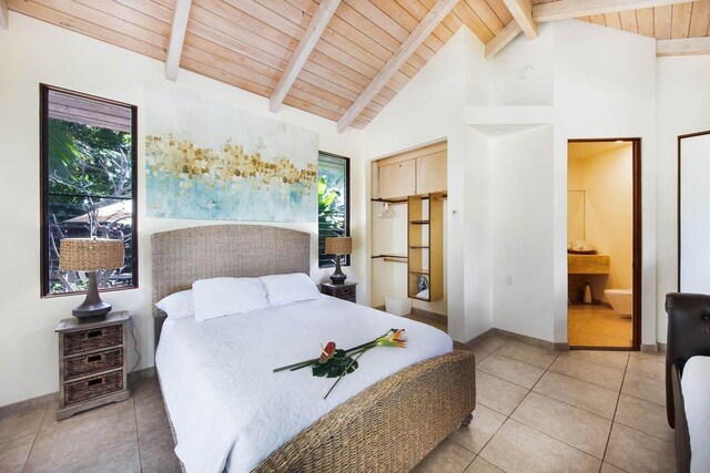 bedroom with tile patterned floors, ensuite bathroom, beam ceiling, and wood ceiling