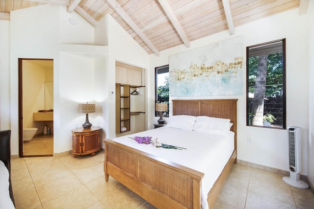 bedroom with beam ceiling, light tile patterned flooring, wood ceiling, and connected bathroom