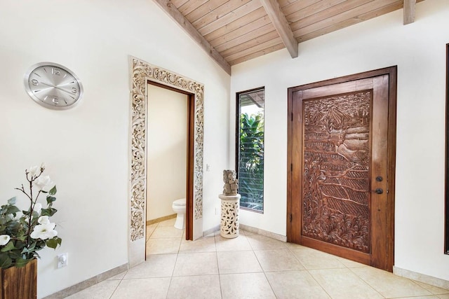 tiled entrance foyer with vaulted ceiling with beams and wood ceiling