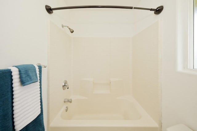 bathroom with bathing tub / shower combination and toilet