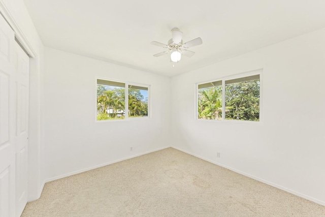 unfurnished room featuring baseboards, light carpet, and ceiling fan