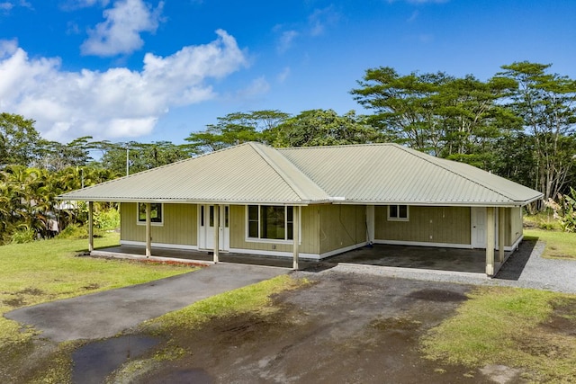 view of front of home with driveway, a front lawn, covered porch, metal roof, and a carport