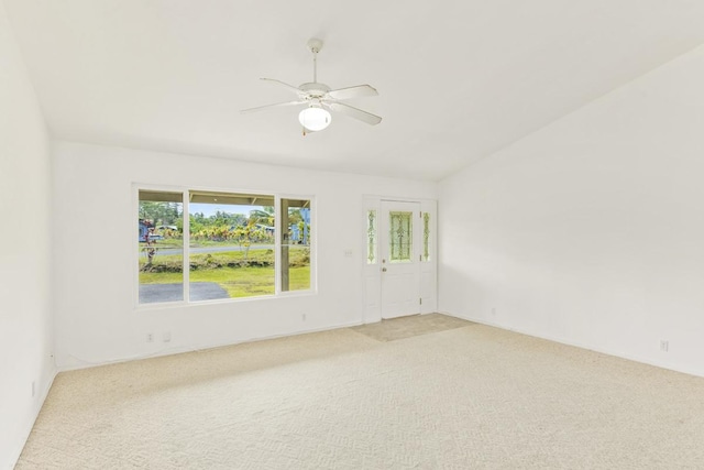 unfurnished room featuring lofted ceiling, a ceiling fan, and light colored carpet