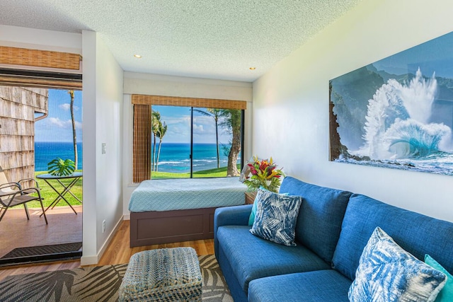 interior space featuring a water view, a textured ceiling, and hardwood / wood-style flooring