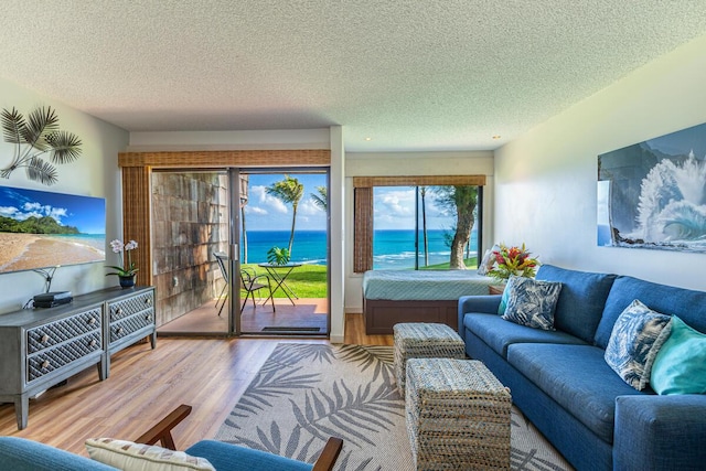 living room featuring hardwood / wood-style floors, a water view, and a textured ceiling