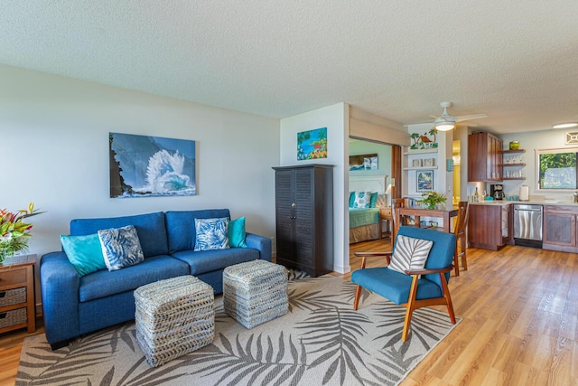 living room featuring a textured ceiling, light hardwood / wood-style flooring, and ceiling fan