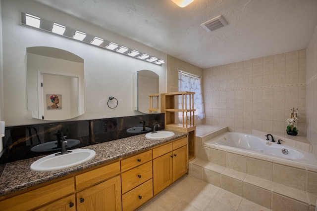 bathroom featuring tile patterned flooring, vanity, a relaxing tiled tub, and tile walls