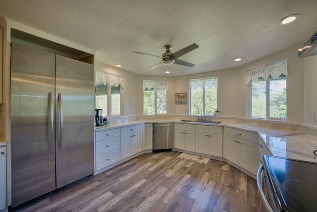 kitchen featuring sink, ceiling fan, appliances with stainless steel finishes, light hardwood / wood-style floors, and white cabinetry