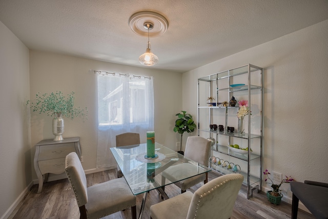 dining space featuring hardwood / wood-style floors and a textured ceiling