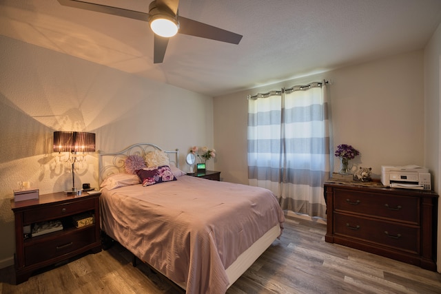 bedroom with ceiling fan and wood-type flooring