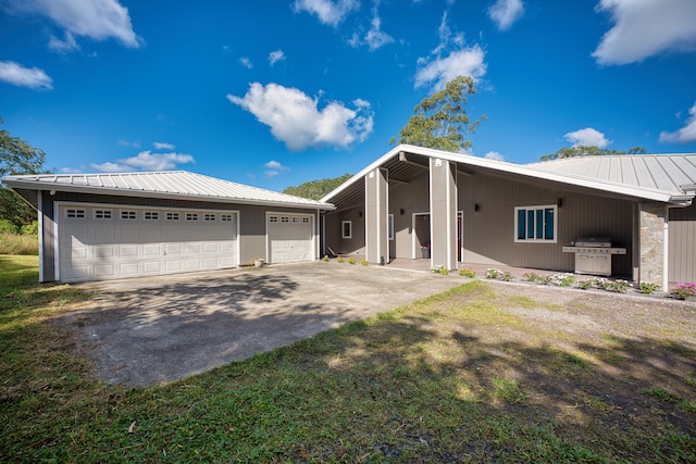 ranch-style home with a garage and a front lawn