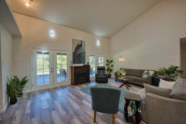 living room with french doors, high vaulted ceiling, and hardwood / wood-style floors