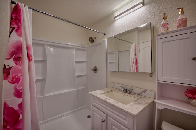 bathroom with a shower with curtain, vanity, and a textured ceiling